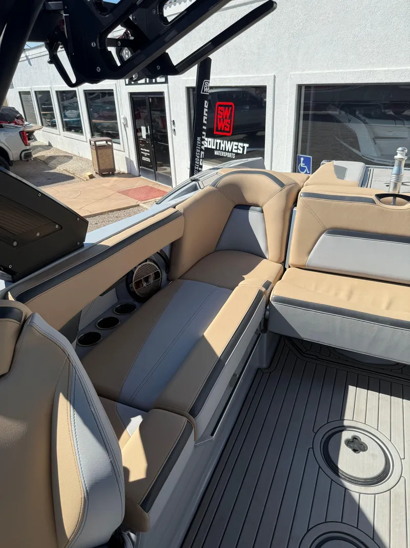 Slide: The Image of 2022 MasterCraft XStarS boat interior with beige and gray seating, cup holders, and modern design. - 8