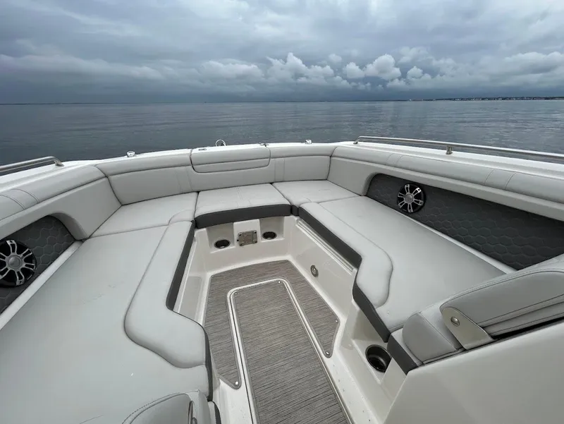 Slide: The Image of 2020 Sea Ray SDX 290 Outboard boat interior with spacious seating and overcast sky. - 11