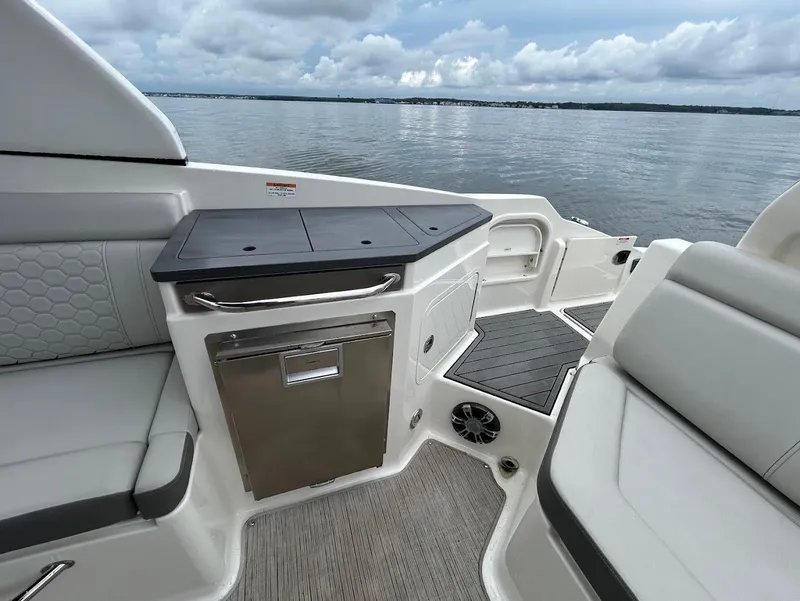 Slide: The Image of 2020 Sea Ray SDX 290 Outboard interior with seating and storage, overlooking calm waters. - 21