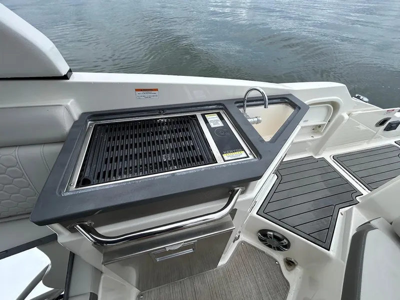 Slide: The Image of 2020 Sea Ray SDX 290 Outboard boat with onboard grill and sink, docked on water. - 22