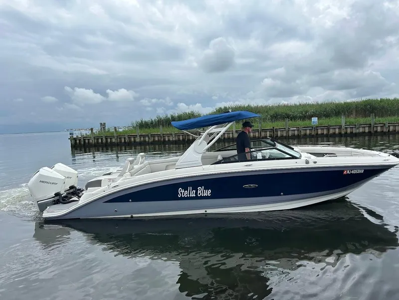 Slide: The Image of 2020 Sea Ray SDX 290 Outboard boat named "Stella Blue" on calm water. - 5