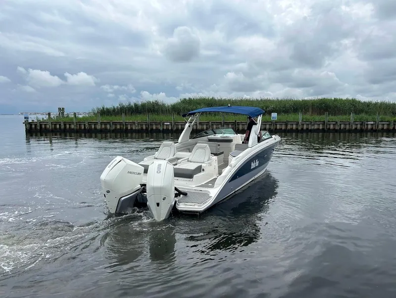 Slide: The Image of 2020 Sea Ray SDX 290 Outboard boat on calm water, cloudy sky backdrop. - 7