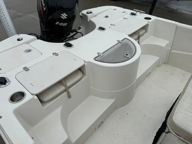 Slide: The Image of 2014 Carolina Skiff 218 DLV boat interior with Suzuki 140 engine, featuring storage compartments. - 10