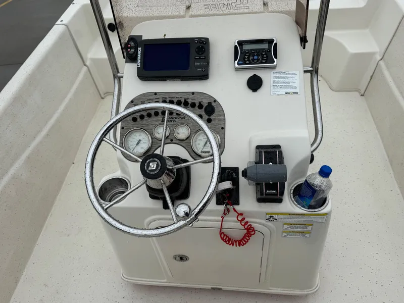 Slide: The Image of Control console of a 2014 Carolina Skiff 218 DLV boat with steering wheel and gauges. - 12
