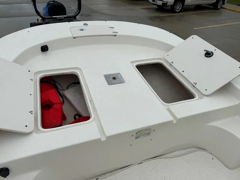 Slide: The Image of 2014 Carolina Skiff 218 DLV boat with open storage compartments and visible life jackets. - 17