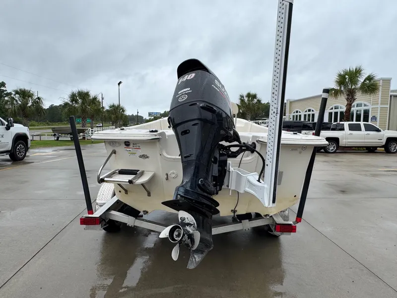Slide: The Image of 2014 Carolina Skiff 218 DLV boat on trailer with outboard motor, parked outdoors. - 3