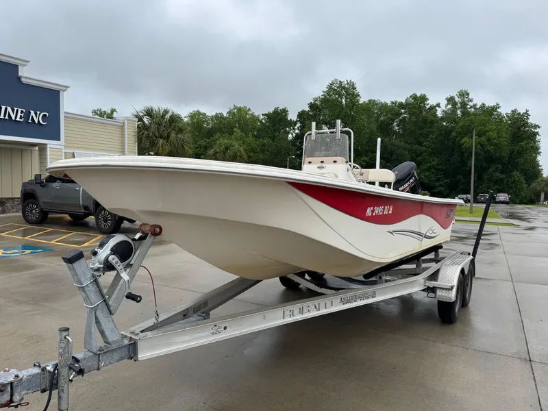 Slide: The Image of 2014 Carolina Skiff 218 DLV boat on trailer, parked outside a marine store. - 5