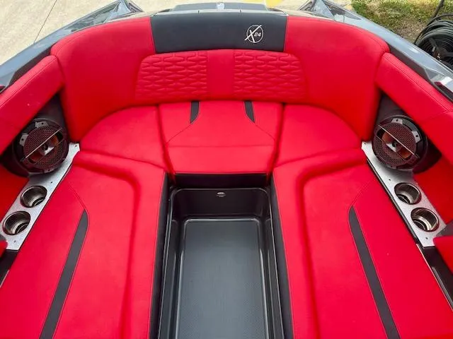 Slide: The Image of 2021 MasterCraft X24 boat interior with vibrant red seating and built-in speakers. - 10