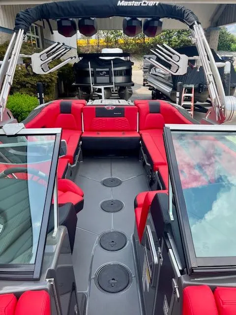 Slide: The Image of 2021 MasterCraft X24 boat with red seating and sleek design. - 11