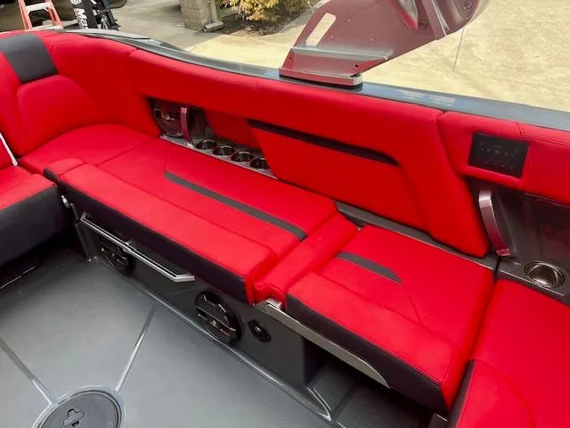 Slide: The Image of Red interior seating of 2021 MasterCraft X24 boat, featuring cup holders and sleek design. - 16