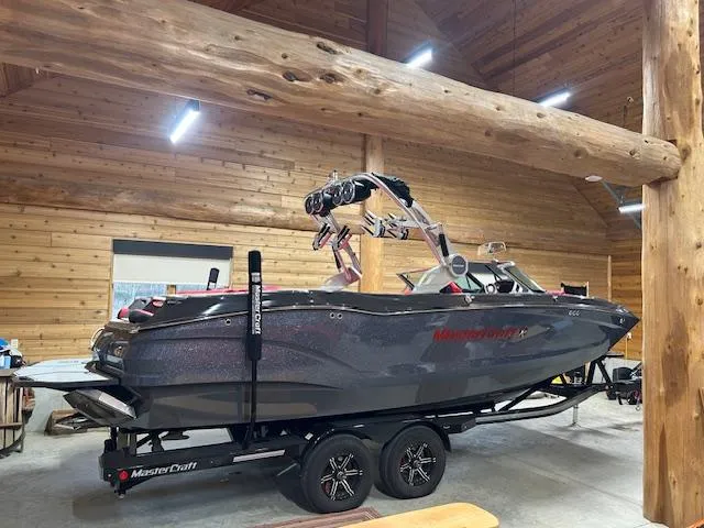 Slide: The Image of 2021 MasterCraft X24 boat in wooden garage on trailer. - 19