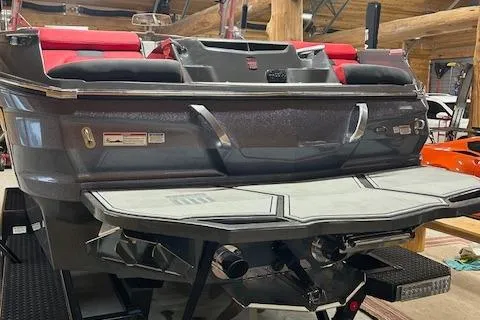 Slide: The Image of 2021 MasterCraft X24 boat with red seating and sleek design in a showroom. - 20