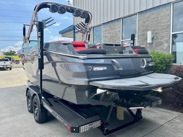 Slide: The Image of 2021 MasterCraft X24 boat on trailer, gray exterior, parked outside a building. - 3