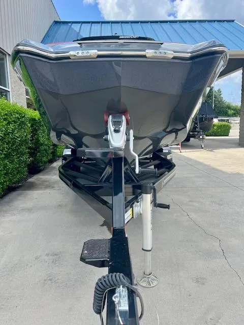 Slide: The Image of 2021 MasterCraft X24 boat on trailer, parked outdoors, front view. - 5