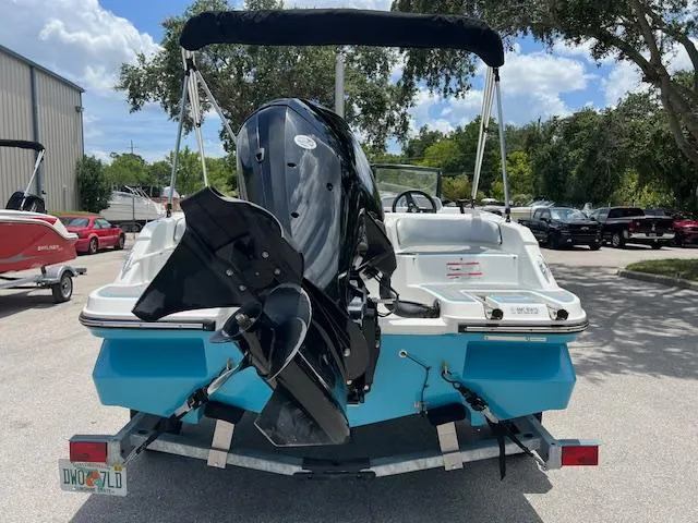 Slide: The Image of 2023 Bayliner Element M17 boat on trailer, rear view with outboard motor. - 2
