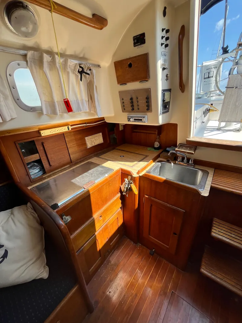 Slide: The Image of 1978 Bristol 29.9 yacht interior with wooden cabinetry, sink, and nautical decor. - 10