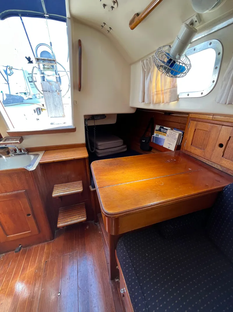 Slide: The Image of 1978 Bristol 29.9 yacht interior with wooden table, sink, and seating area. - 11