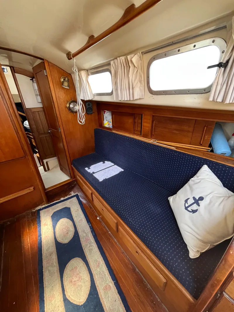 Slide: The Image of 1978 Bristol 29.9 yacht interior with wooden finish, blue sofa, and nautical-themed decor. - 13