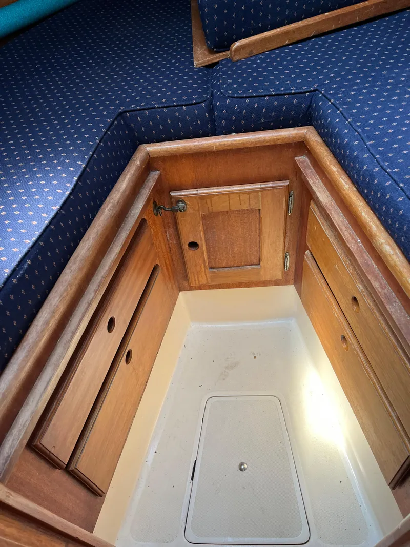 Slide: The Image of 1978 Bristol 29.9 sailboat interior with wooden cabinetry and blue cushioned seating. - 15