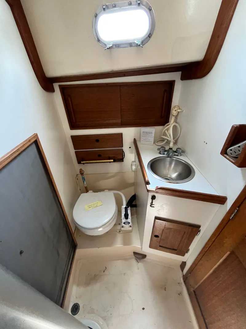 Slide: The Image of 1978 Bristol 29.9 yacht bathroom with toilet, sink, and wooden cabinetry. - 17