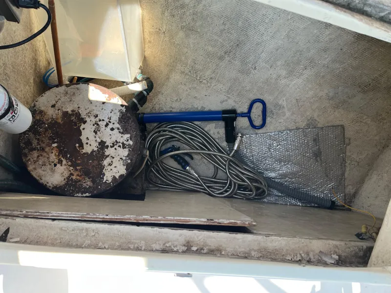 Slide: The Image of Storage compartment in a 1978 Bristol 29.9 sailboat with coiled hose and equipment. - 18