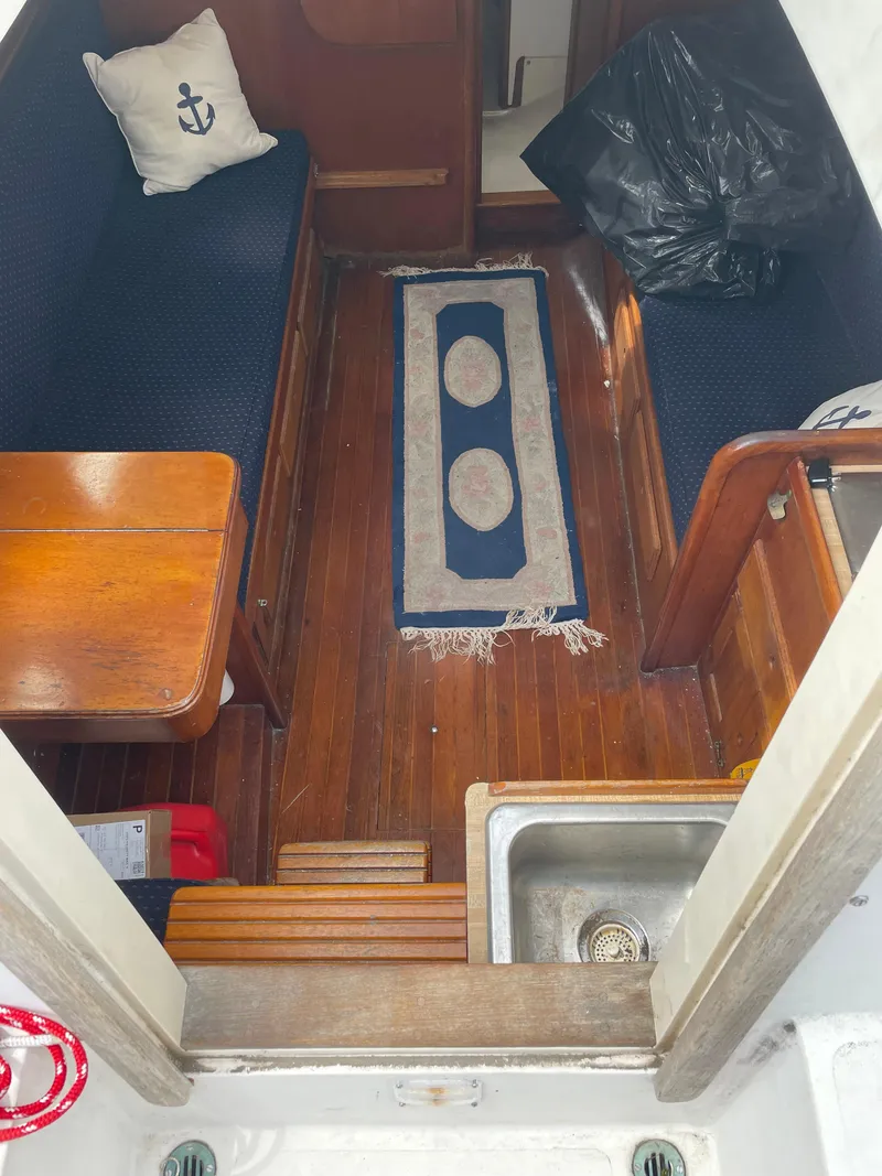 Slide: The Image of Interior of a 1978 Bristol 29.9 sailboat with wooden flooring and nautical decor. - 9