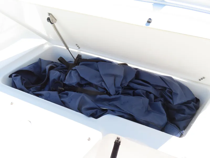 Slide: The Image of Storage compartment of 2016 Sea Hunt Ultra 234 boat with blue cover inside. - 14