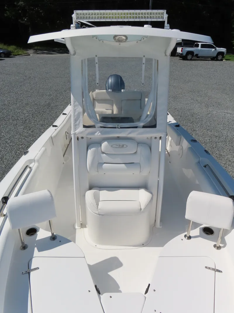 Slide: The Image of 2016 Sea Hunt Ultra 234 boat with center console and seating, parked on gravel. - 17