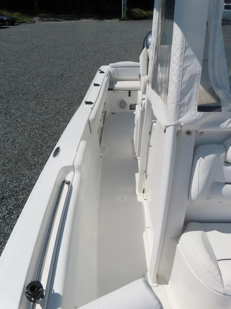 Slide: The Image of 2016 Sea Hunt Ultra 234 boat interior with white seating and clean deck. - 18