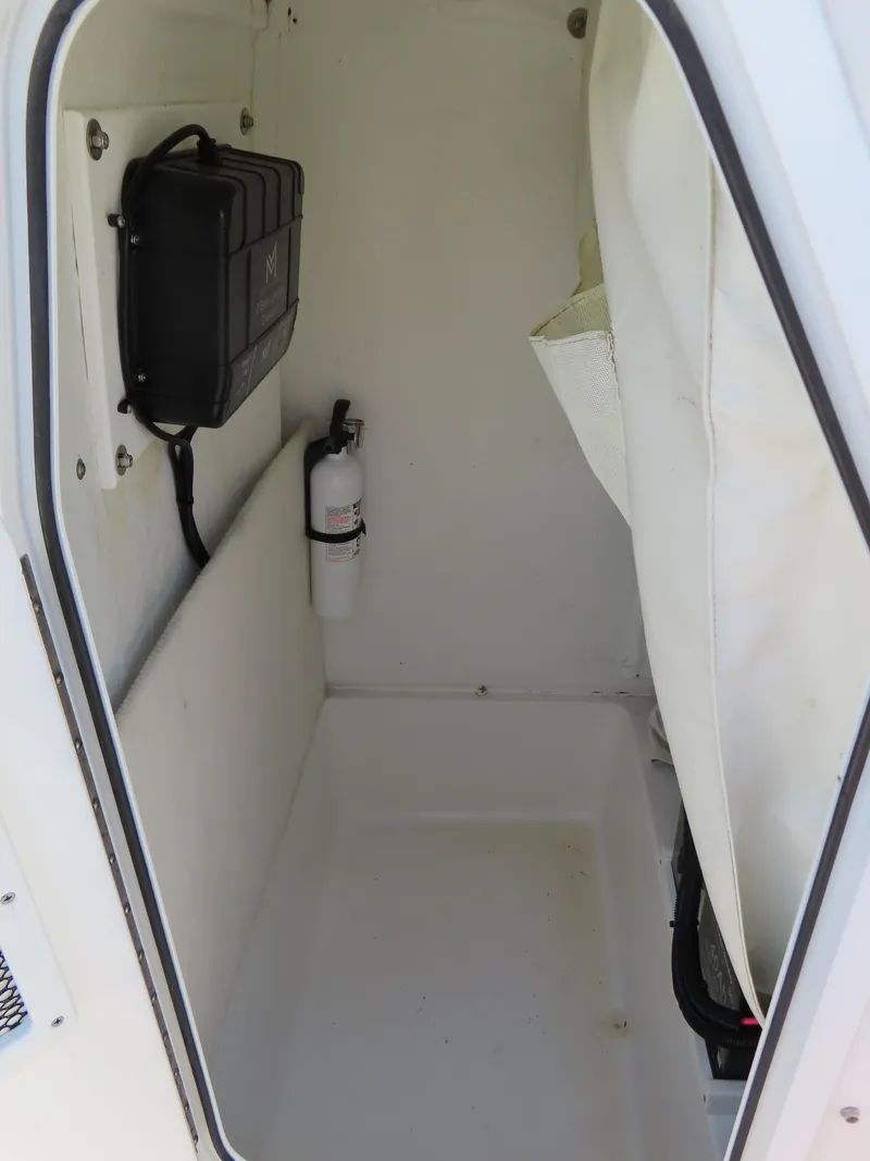 Slide: The Image of Interior storage compartment of 2016 Sea Hunt Ultra 234 boat with fire extinguisher. - 23