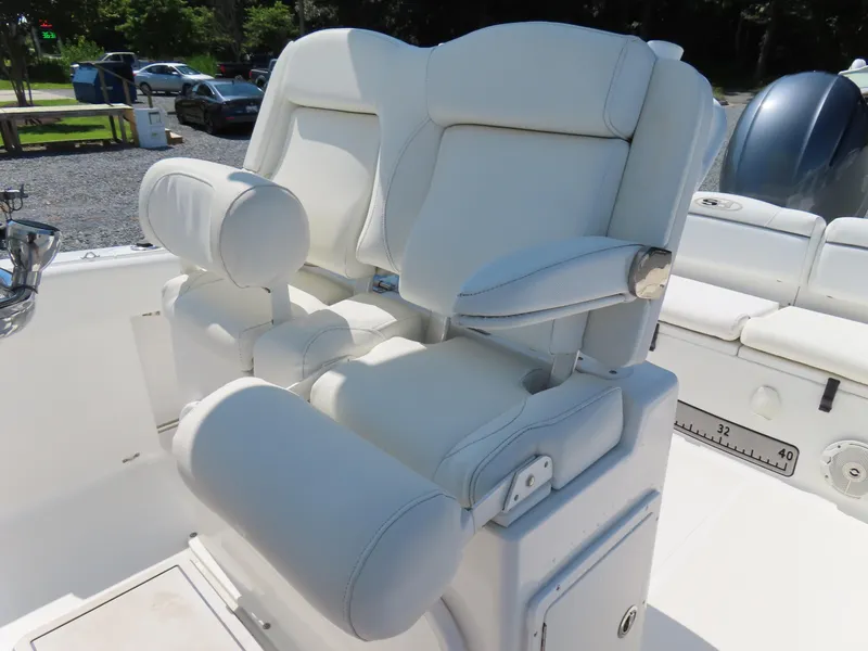 Slide: The Image of 2016 Sea Hunt Ultra 234 boat seating with white cushioned captain's chairs and armrests. - 26