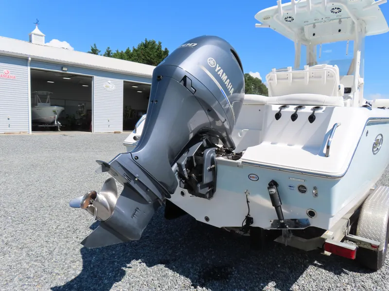 Slide: The Image of 2016 Sea Hunt Ultra 234 boat with Yamaha outboard motor, parked near a garage. - 3