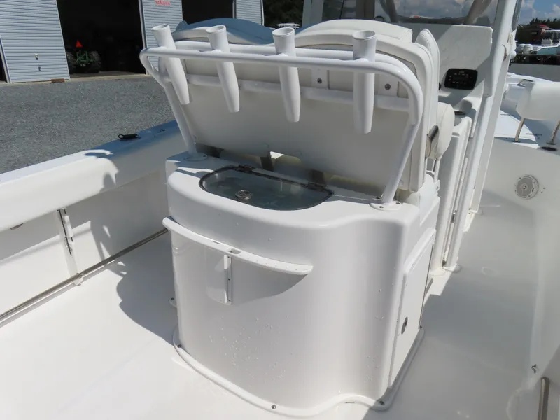 Slide: The Image of 2016 Sea Hunt Ultra 234 boat interior with open storage compartment and rod holders. - 33