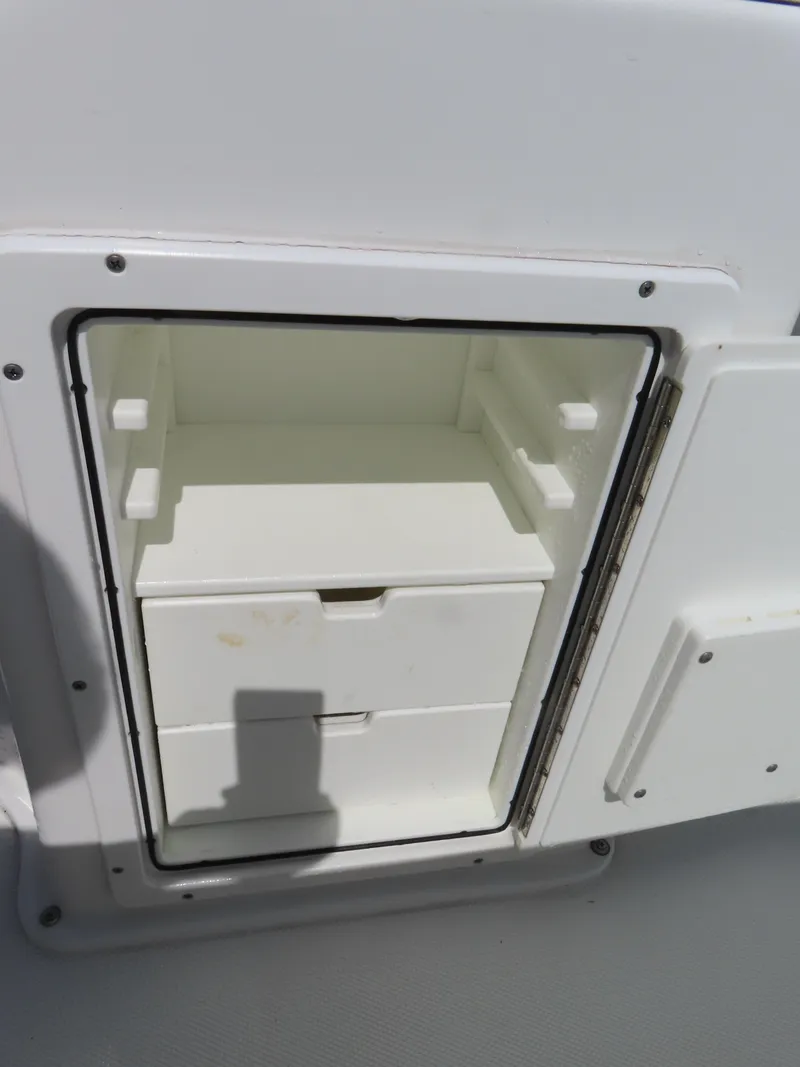 Slide: The Image of Storage compartment on a 2016 Sea Hunt Ultra 234 boat, featuring drawers and shelves. - 38