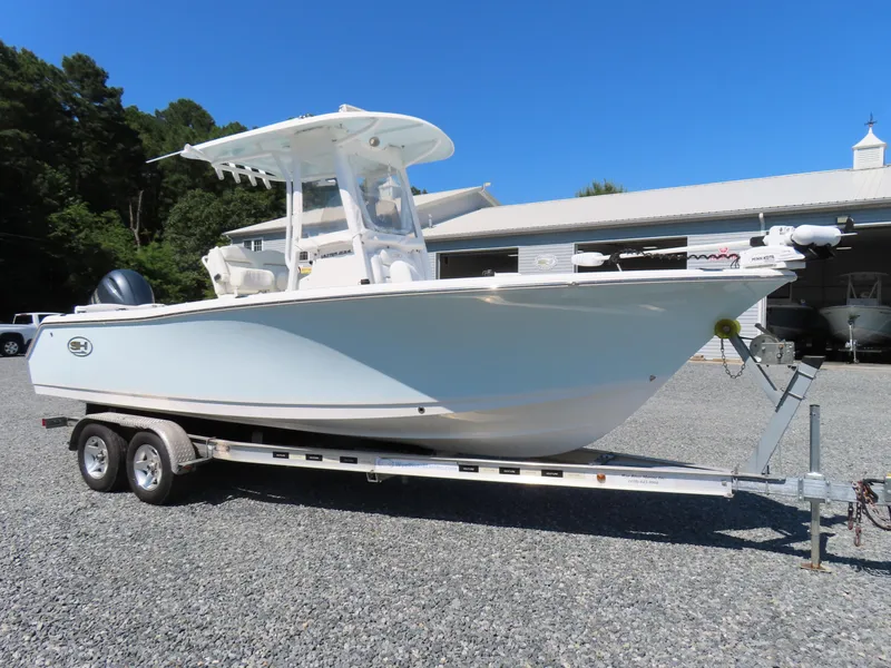 Slide: The Image of 2016 Sea Hunt Ultra 234 boat on trailer, parked outdoors under clear blue sky. - 4