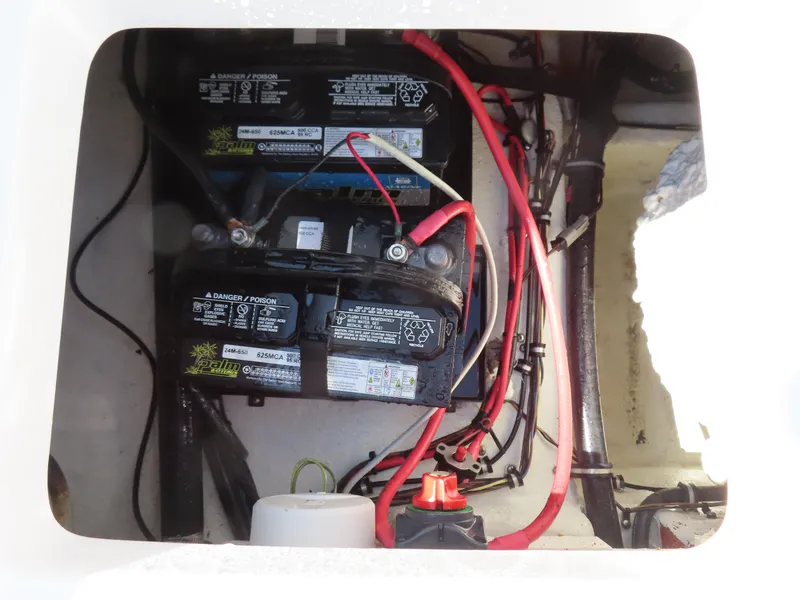 Slide: The Image of Battery compartment of a 2016 Sea Hunt Ultra 234 boat with wiring and connections. - 42