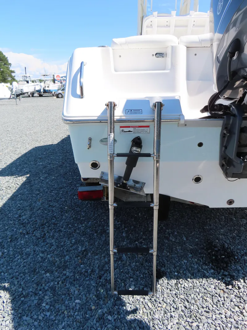 Slide: The Image of 2016 Sea Hunt Ultra 234 boat with extended swim ladder on gravel surface. - 6