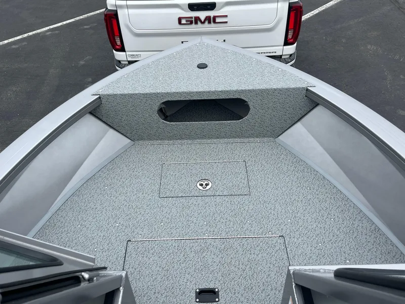 Slide: The Image of 2025 Crestliner 2050 Commander boat interior with textured flooring, parked behind a GMC truck. - 3