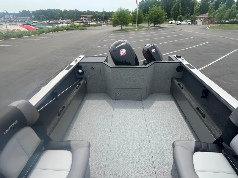 Slide: The Image of 2025 Crestliner 2050 Commander boat interior with dual outboard motors in a parking lot. - 6