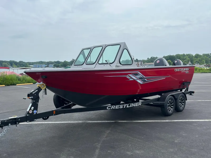 Slide: The Image of 2025 Crestliner 2050 Commander boat in red on a trailer, parked outdoors. - 8