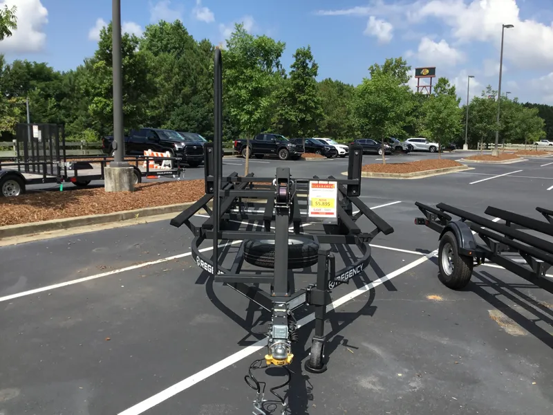 Slide: The Image of 2023 Regency 250 Tri-toon trailer in parking lot, surrounded by trees and vehicles. - 2