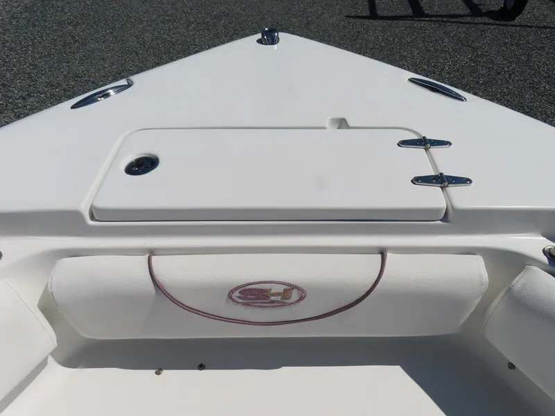 Slide: The Image of 2019 Sea Hunt Ultra 234 boat bow with storage compartment and cushioned seating. - 10