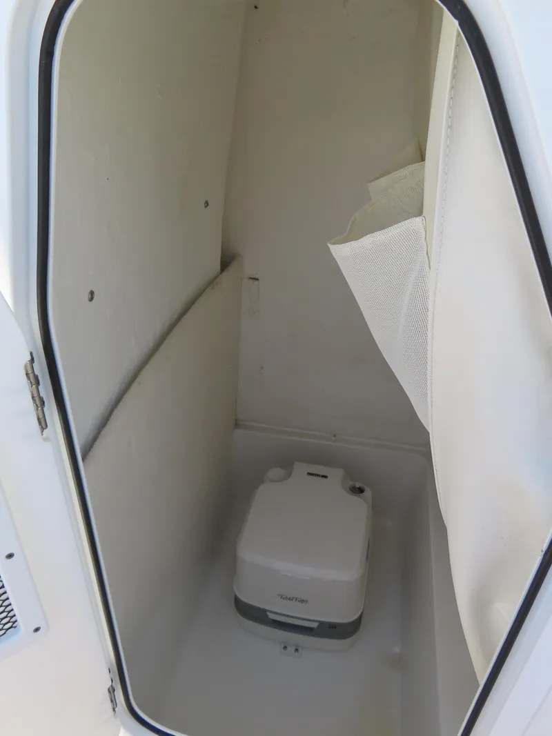 Slide: The Image of 2019 Sea Hunt Ultra 234 boat storage compartment with portable toilet. - 18