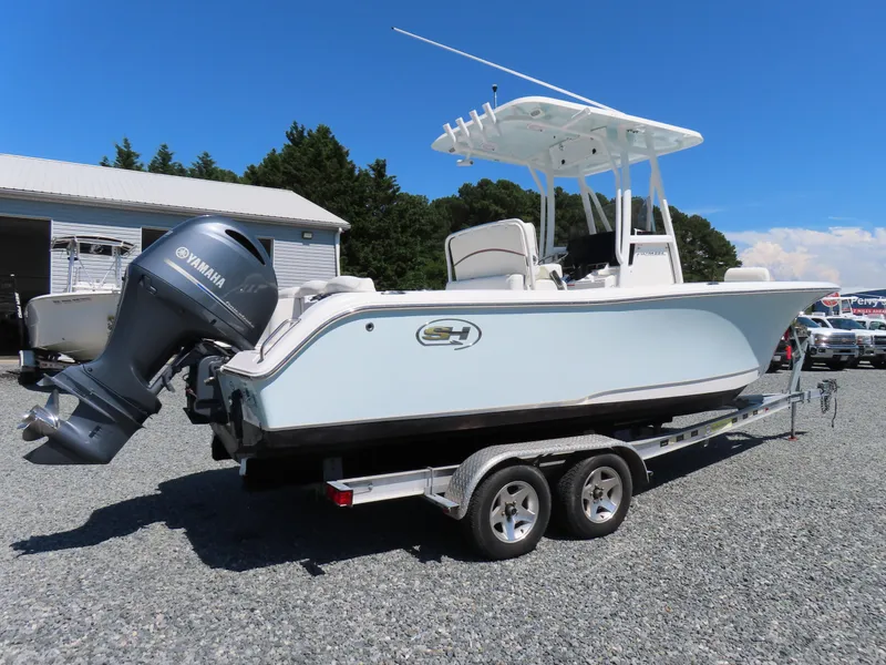 Slide: The Image of 2019 Sea Hunt Ultra 234 boat on trailer with Yamaha engine, parked outdoors. - 2