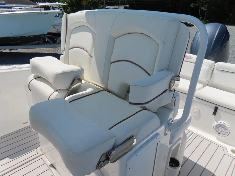 Slide: The Image of 2019 Sea Hunt Ultra 234 boat seating with white cushioned captain's chair and armrests. - 21