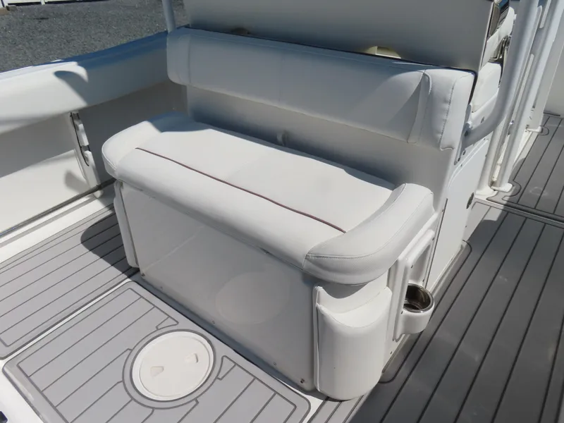 Slide: The Image of 2019 Sea Hunt Ultra 234 boat interior with white cushioned seating and gray flooring. - 28