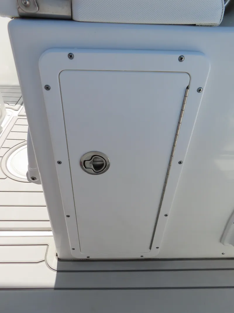 Slide: The Image of 2019 Sea Hunt Ultra 234 boat storage compartment with latch on deck. - 32