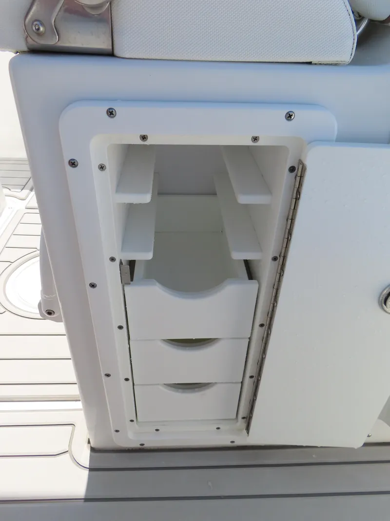 Slide: The Image of Storage compartment with drawers on a 2019 Sea Hunt Ultra 234 boat. - 33