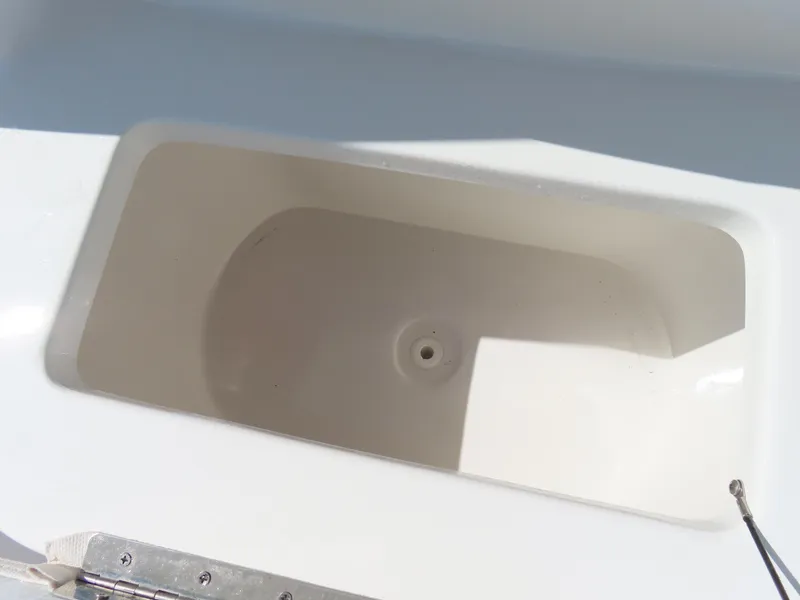 Slide: The Image of 2023 Sea Hunt Ultra 229 boat storage compartment, white interior, open lid. - 17