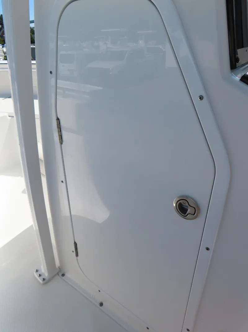 Slide: The Image of 2023 Sea Hunt Ultra 229 boat cabin door, white exterior. - 18